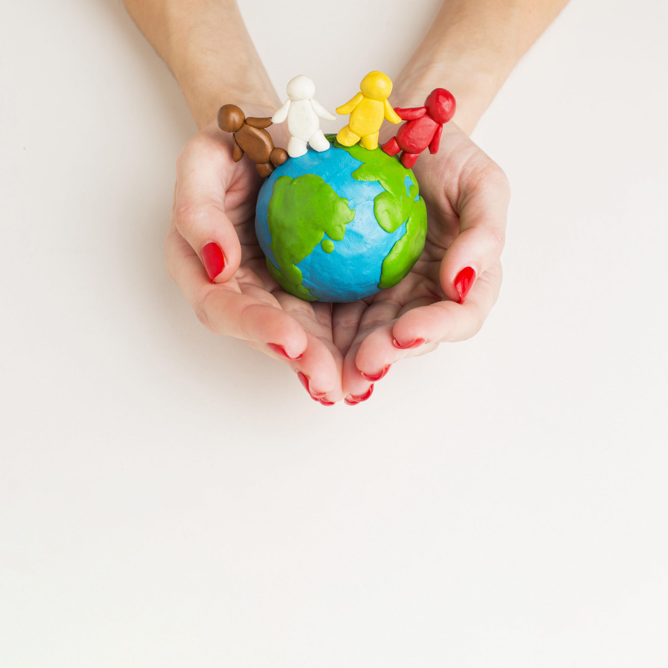 top-view-hands-holding-globe-with-people-figurines