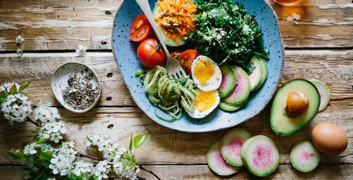 poached egg with vegetables and tomatoes on blue plate