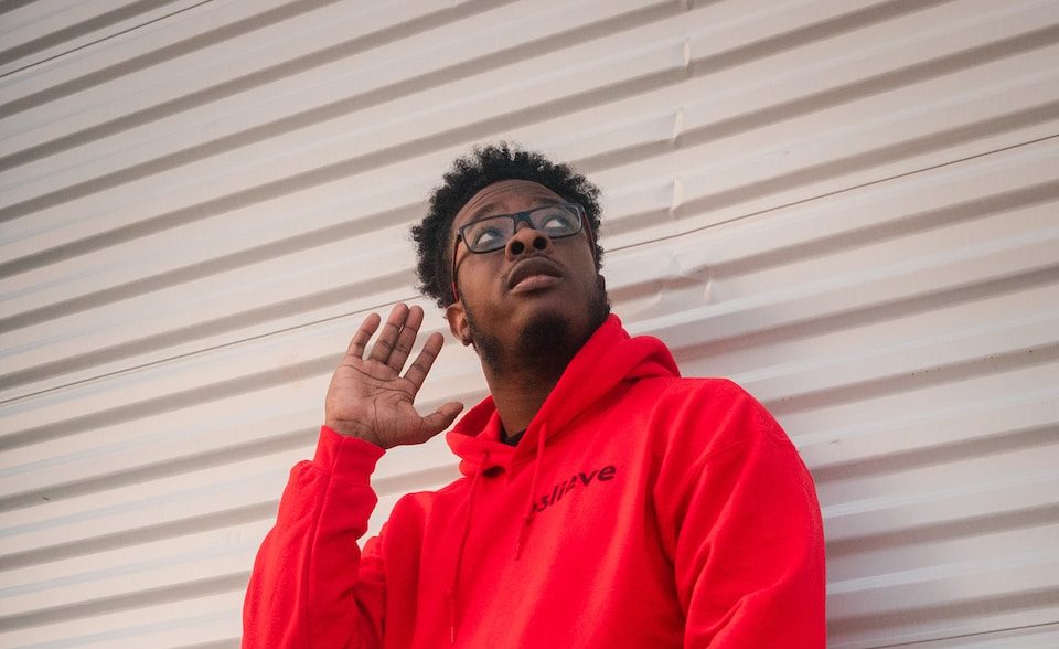 man in red dress shirt and blue denim jeans