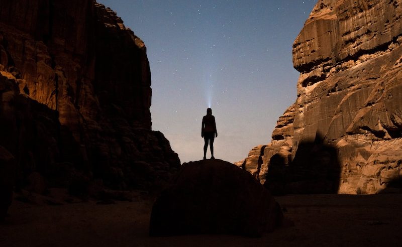 a person standing in the middle of a desert at night