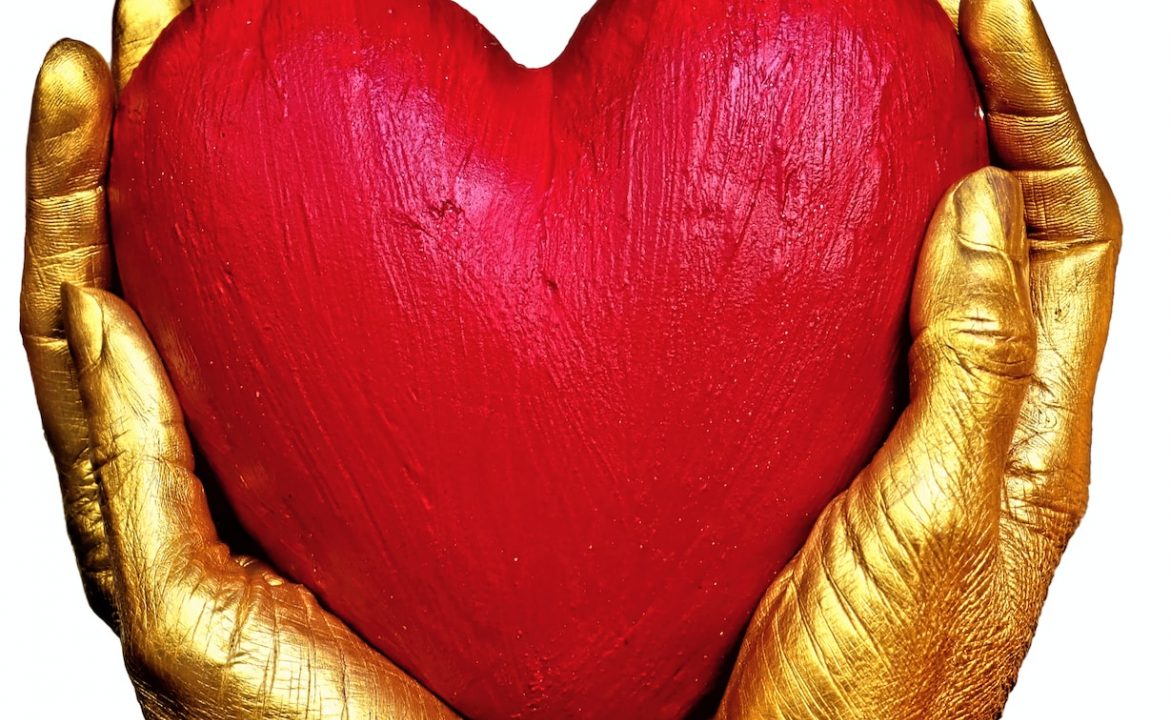 person holding red heart shaped ornament