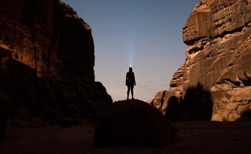 a person standing in the middle of a desert at night