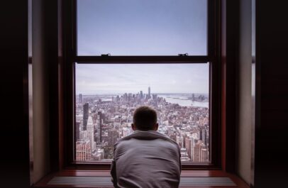 Photo by Norbert Kundrak man in gray shirt looking at city buildings during daytime