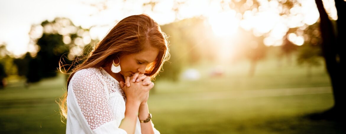 Photo by Ben White woman praying beside tree