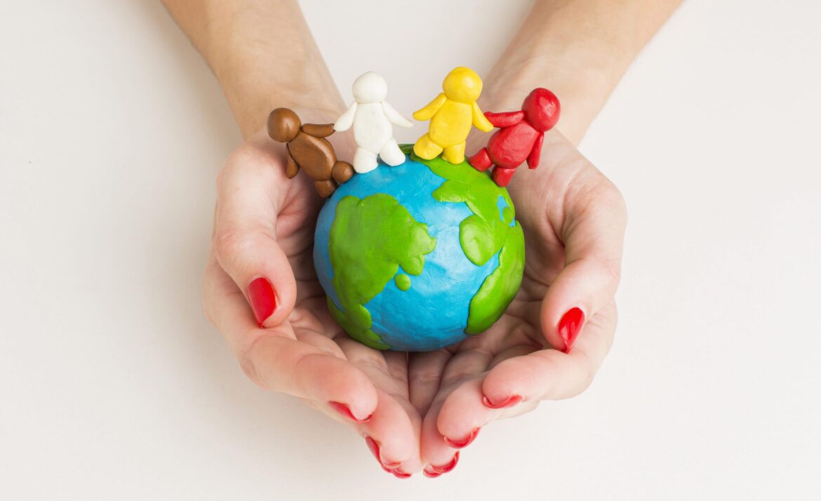 top-view-hands-holding-globe-with-people-figurines